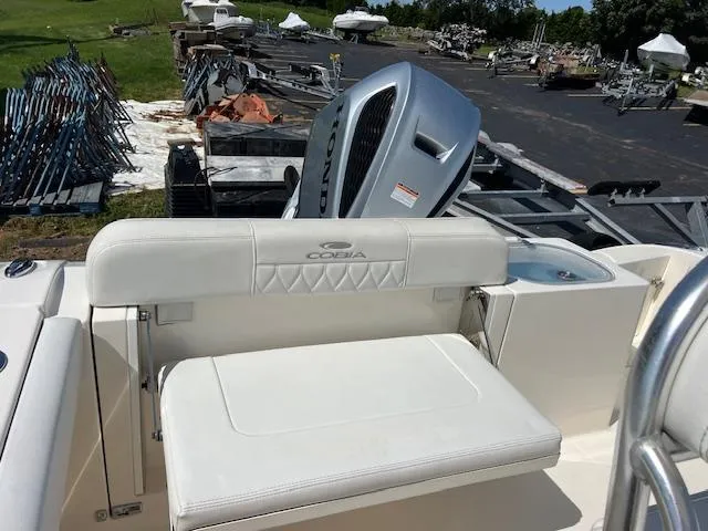 Slide: The Image of 2020 Cobia 237 Center Console boat with Honda outboard motor in a storage yard. - 10