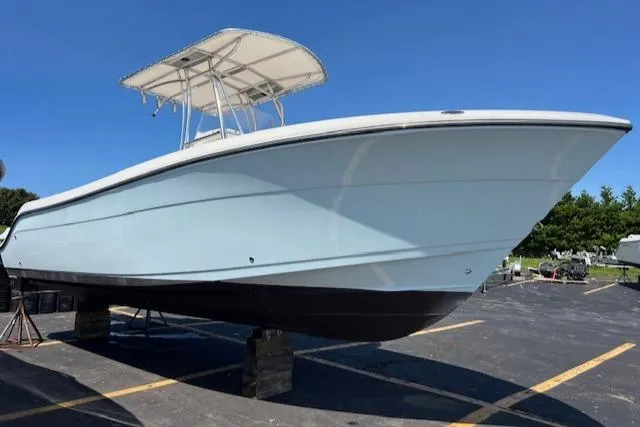 Slide: The Image of 2020 Cobia 237 Center Console boat on display in a parking lot. - 2