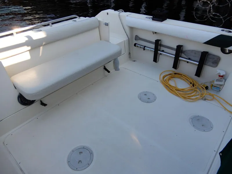 Slide: The Image of 1999 Pursuit 2860 Denali boat deck with seating, paddle, and coiled rope. - 11