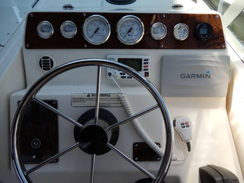Slide: The Image of 1999 Pursuit 2860 Denali boat dashboard with steering wheel, gauges, and Garmin navigation system. - 6