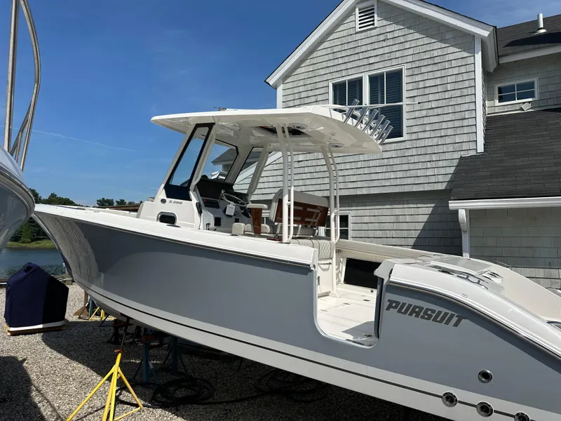 Slide: The Image of 2025 Pursuit S 288 Sport boat on display near a house. - 0
