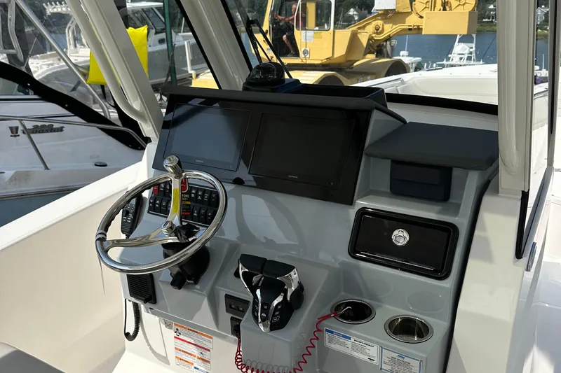 Slide: The Image of 2025 Pursuit S 288 Sport boat dashboard with steering wheel and controls. - 3