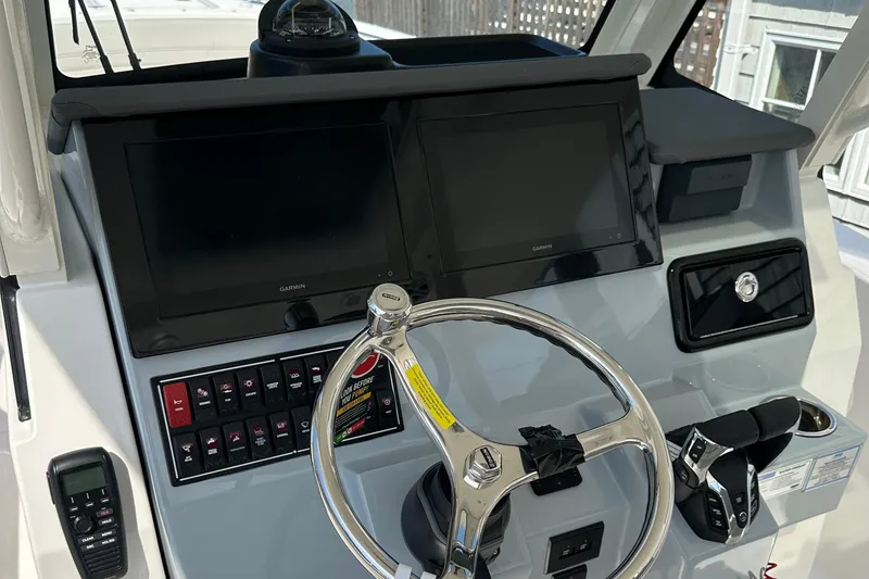 Slide: The Image of 2025 Pursuit S 288 Sport boat dashboard with dual screens and steering wheel. - 4