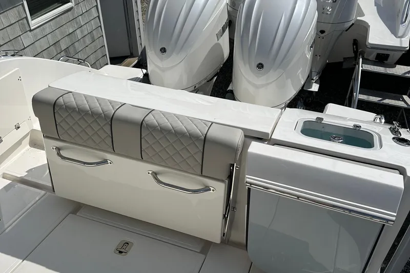 Slide: The Image of 2025 Pursuit S 288 Sport boat interior with cushioned seating and dual outboard motors. - 9