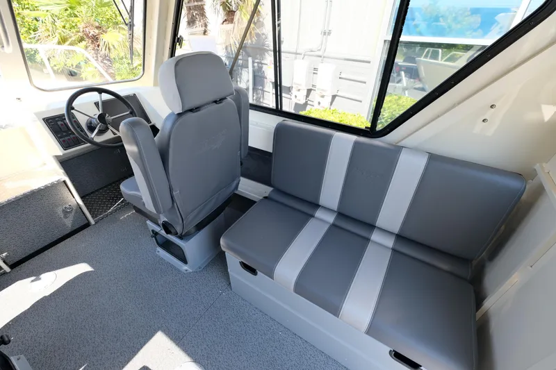 Slide: The Image of Interior of 2025 Hewescraft 220 Ocean Pro ET HT, featuring gray seating and steering area. - 10