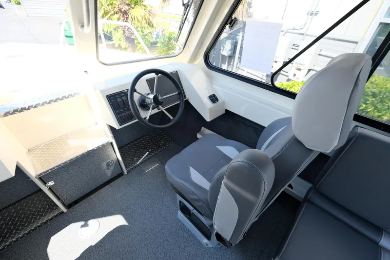Slide: The Image of Interior of 2025 Hewescraft 220 Ocean Pro ET HT boat, featuring steering wheel and seating. - 11