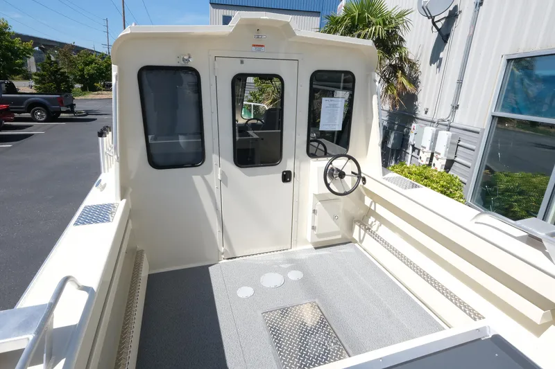 Slide: The Image of 2025 Hewescraft 220 Ocean Pro ET HT boat interior with steering wheel and cabin door. - 4