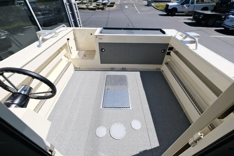 Slide: The Image of 2025 Hewescraft 220 Ocean Pro ET HT boat interior with steering wheel and storage compartments. - 6