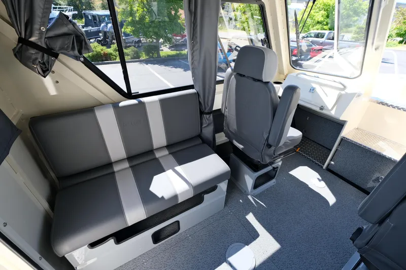 Slide: The Image of Interior of 2025 Hewescraft 220 Ocean Pro ET HT boat, featuring seating and windows. - 9
