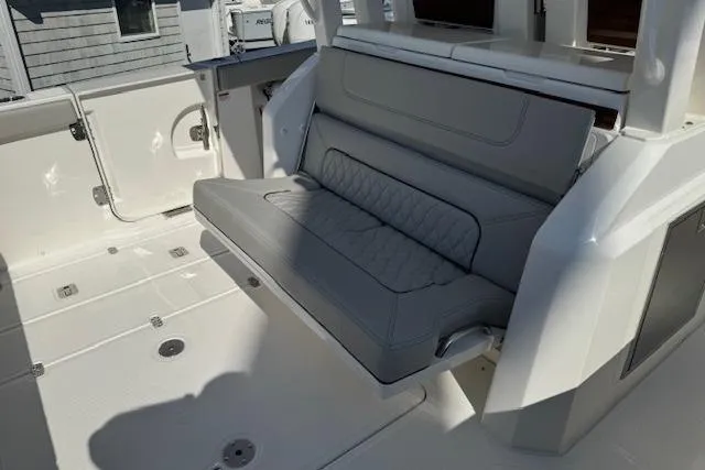 Slide: The Image of 2026 Pursuit S 328 Sport boat with gray cushioned seating and spacious deck. - 11