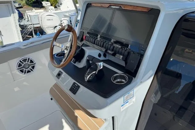Slide: The Image of 2026 Pursuit S 328 Sport boat dashboard with steering wheel and control panel. - 14