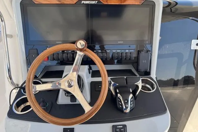 Slide: The Image of 2026 Pursuit S 328 Sport boat dashboard with steering wheel and control panel. - 16