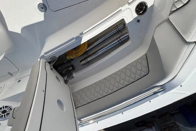 Slide: The Image of 2026 Pursuit S 328 Sport boat interior storage compartment with stainless steel fittings and quilted padding. - 27