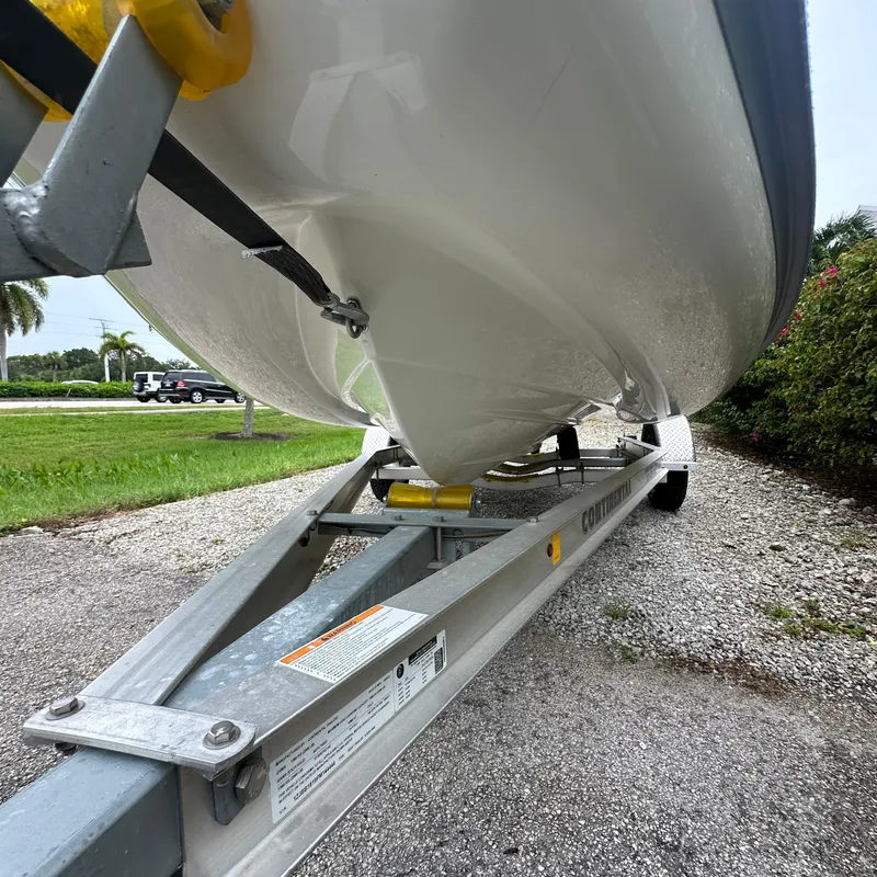 Slide: The Image of 2024 Rigid Boats 17' Sport on trailer, parked on gravel near greenery. - 14