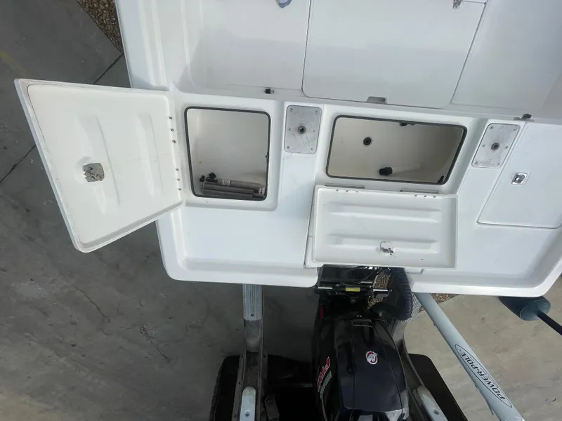 Slide: The Image of 2005 ShearWater 2200 boat deck with open storage compartments and motor. - 11