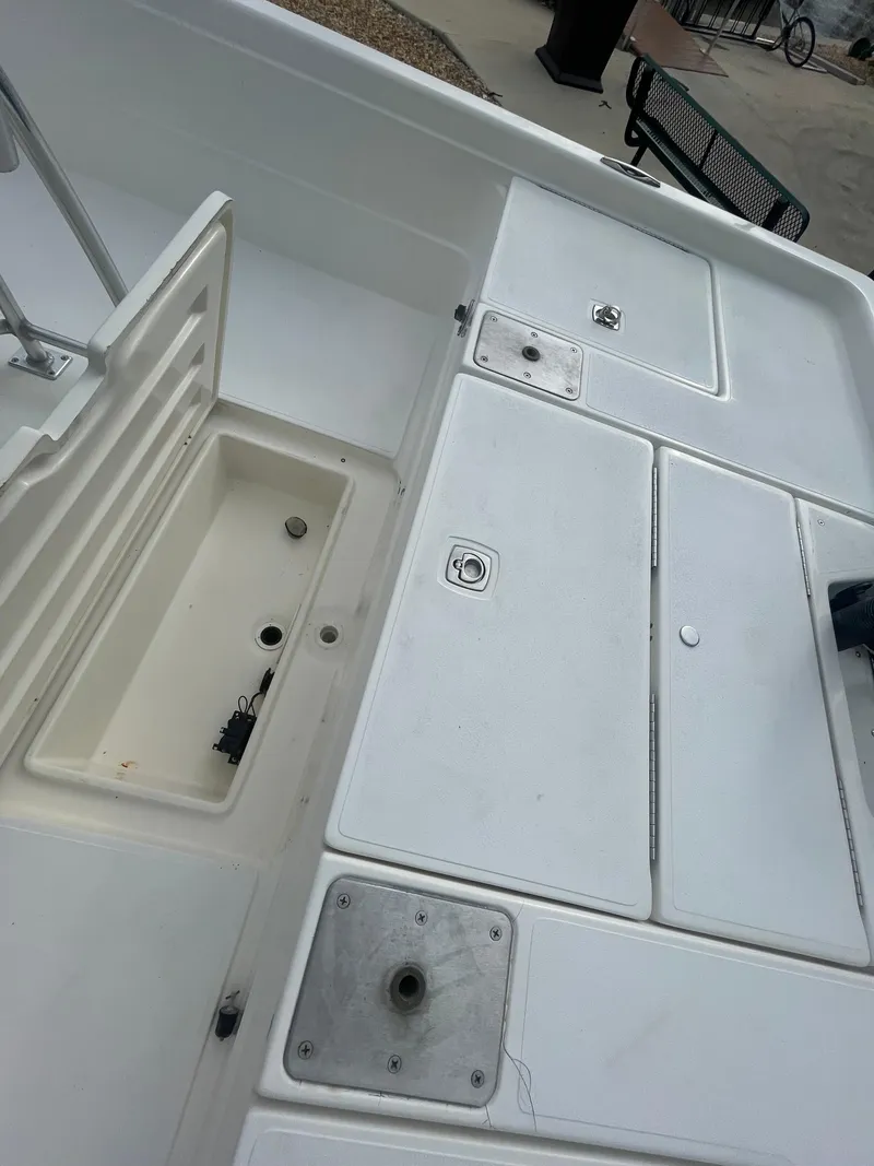 Slide: The Image of 2005 ShearWater 2200 boat deck with storage compartments and seating area. - 12