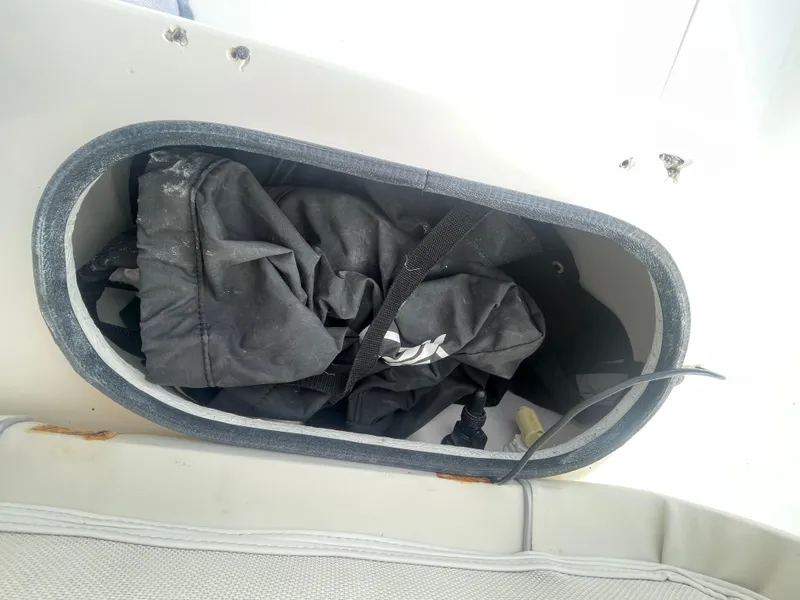 Slide: The Image of Storage compartment on a 2005 ShearWater 2200 boat with black fabric inside. - 13