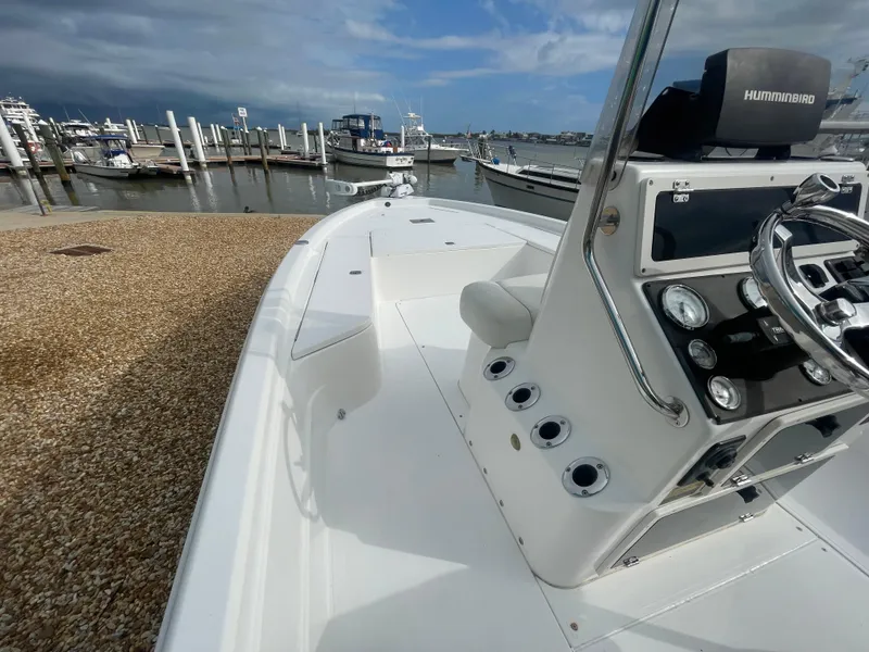 Slide: The Image of 2005 ShearWater 2200 boat at marina, featuring steering console and docked vessels. - 15