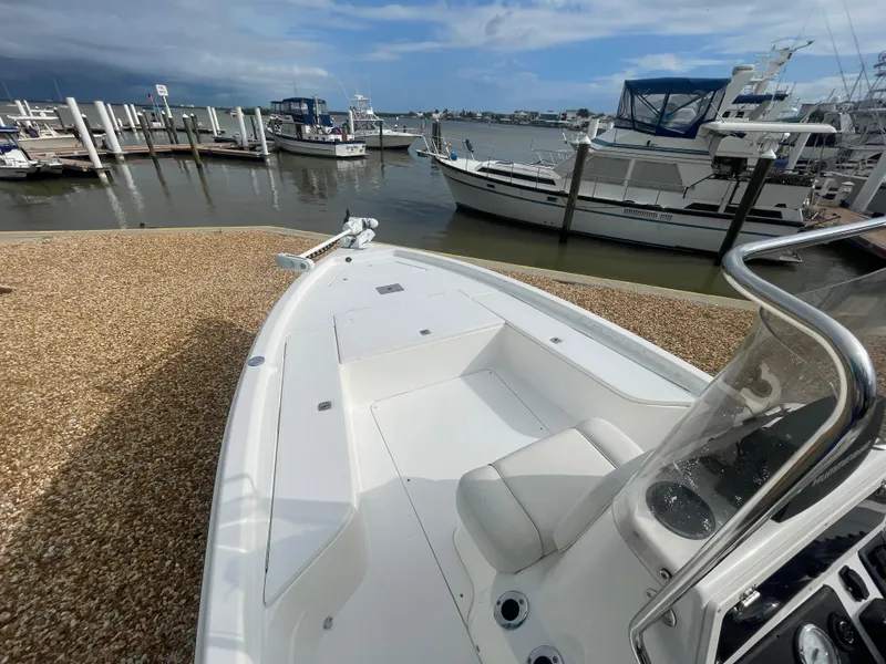 Slide: The Image of 2005 ShearWater 2200 boat docked at a marina with other vessels. - 16