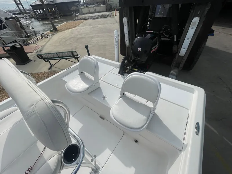 Slide: The Image of 2005 ShearWater 2200 boat interior with white seating and motor in a marina setting. - 18