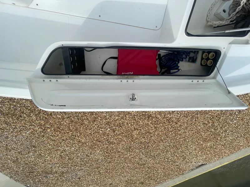 Slide: The Image of Storage compartment on a 2005 ShearWater 2200 boat, containing a red bag and coiled rope. - 19