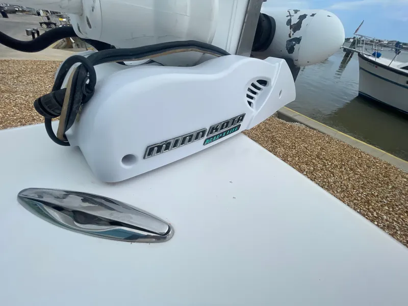 Slide: The Image of White Minn Kota trolling motor on 2005 ShearWater 2200 boat docked by the water. - 24