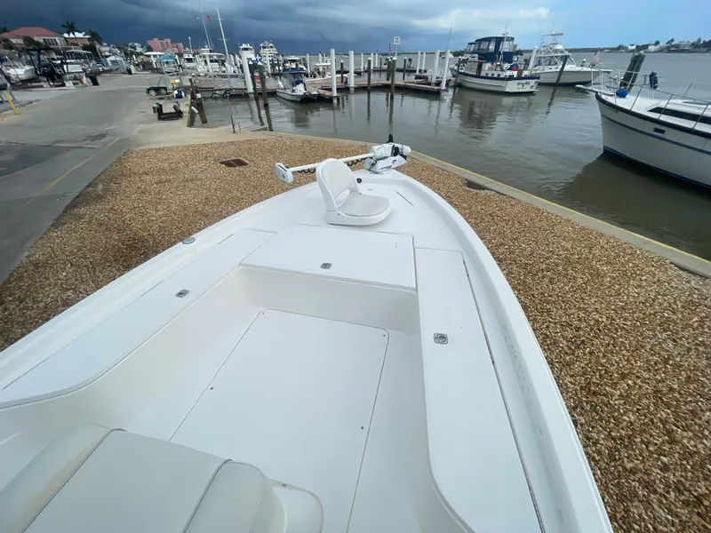Slide: The Image of 2005 ShearWater 2200 boat docked at a marina with cloudy skies. - 25
