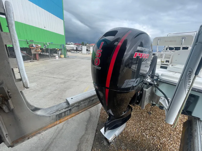 Slide: The Image of Outboard motor on a 2005 ShearWater 2200 boat, parked near a marina. - 28