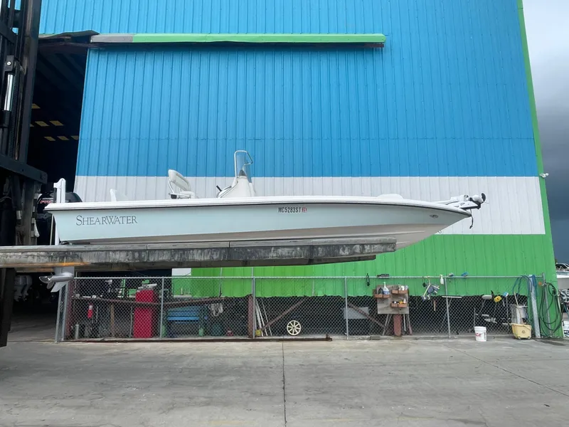 Slide: The Image of 2005 ShearWater 2200 boat suspended in front of a blue and green building. - 31