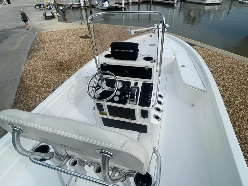Slide: The Image of 2005 ShearWater 2200 boat interior with steering console and seating, dockside view. - 5