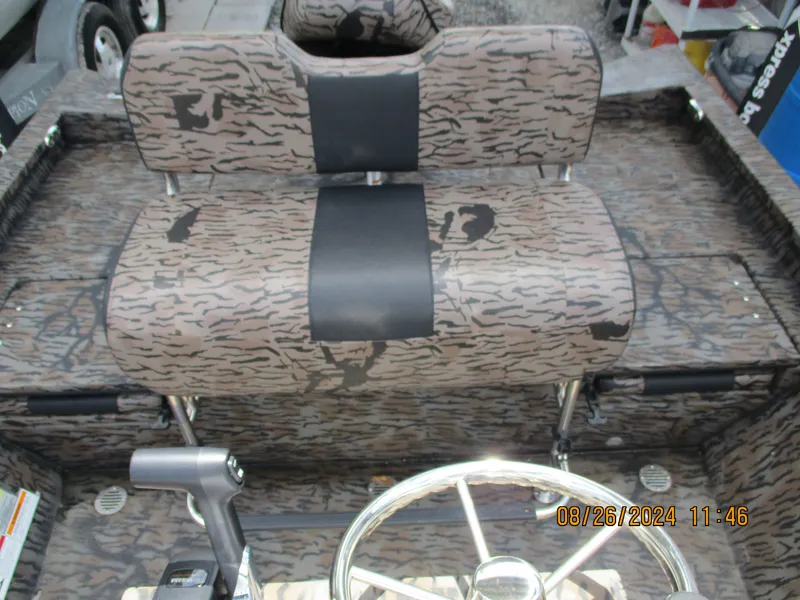 Slide: The Image of 2023 Express H20 Bay boat interior with camo seats and steering wheel. - 7