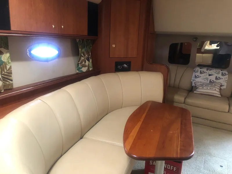 Slide: The Image of 2001 Cruisers Yachts 3672 Express interior with beige seating and wooden table. - 15