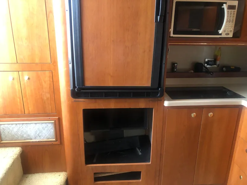 Slide: The Image of 2001 Cruisers Yachts 3672 Express interior kitchen with wood cabinetry and appliances. - 18