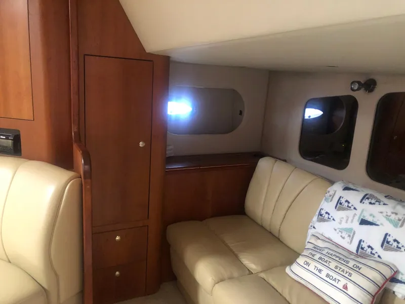 Slide: The Image of 2001 Cruisers Yachts 3672 Express interior with beige seating and wooden cabinetry. - 23