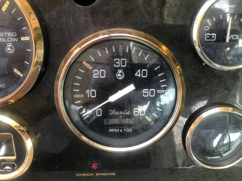Slide: The Image of Close-up of 2001 Cruisers Yachts 3672 Express dashboard gauges, featuring RPM and check engine indicators. - 10