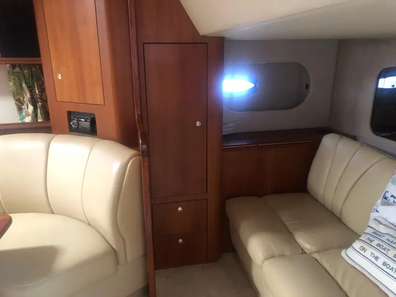 Slide: The Image of Interior of 2001 Cruisers Yachts 3672 Express with beige leather seating and wooden cabinetry. - 21
