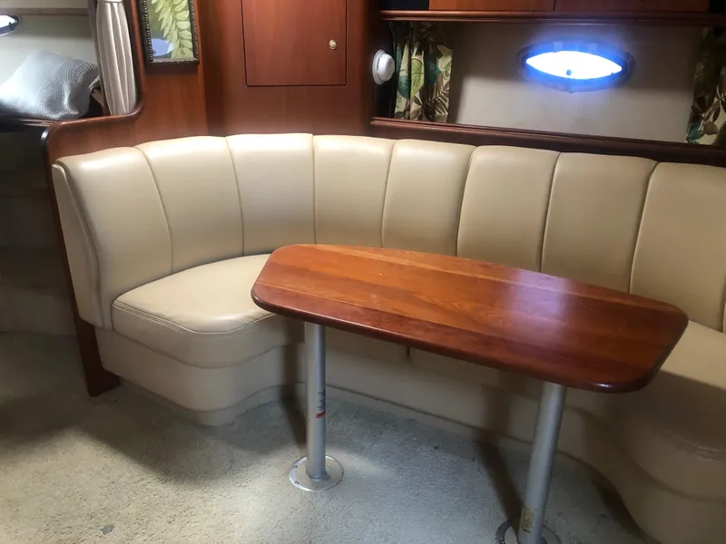 Slide: The Image of 2001 Cruisers Yachts 3672 Express interior with beige seating and wooden table. - 22