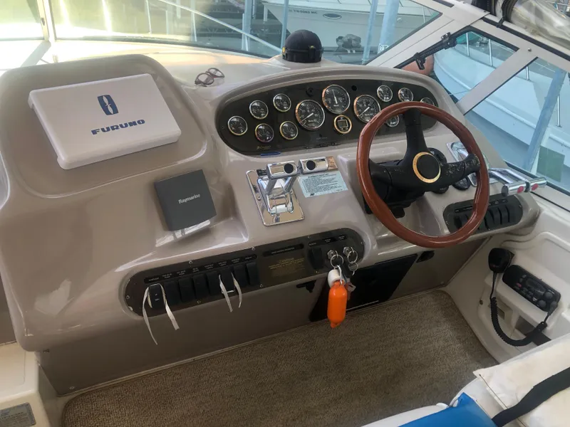 Slide: The Image of 2001 Cruisers Yachts 3672 Express helm with gauges, steering wheel, and navigation equipment. - 6