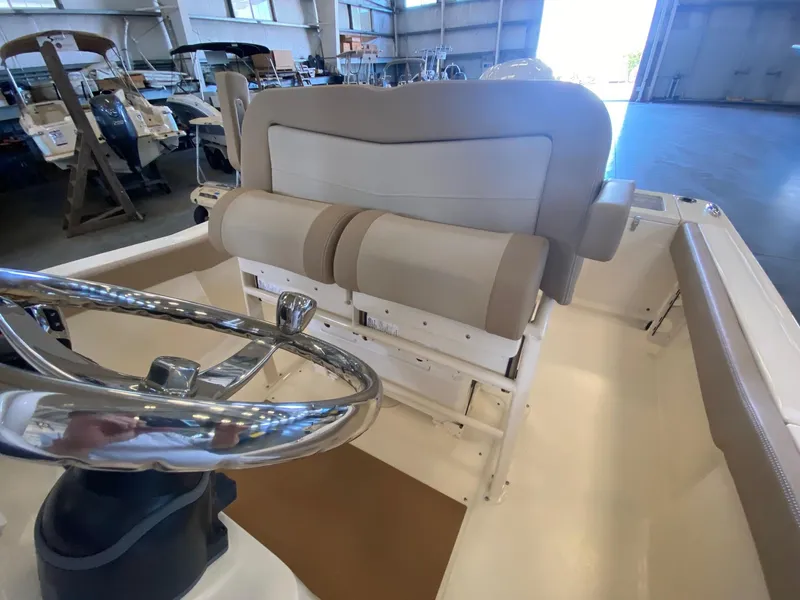 Slide: The Image of 2025 Scout 240 XSF boat interior with steering wheel and seating in a showroom. - 12