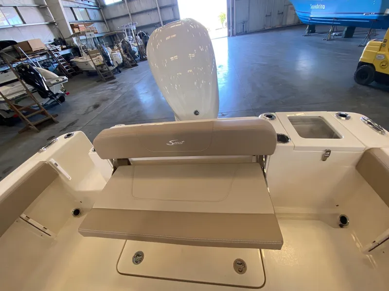 Slide: The Image of 2025 Scout 240 XSF boat interior with beige seating in a warehouse setting. - 13