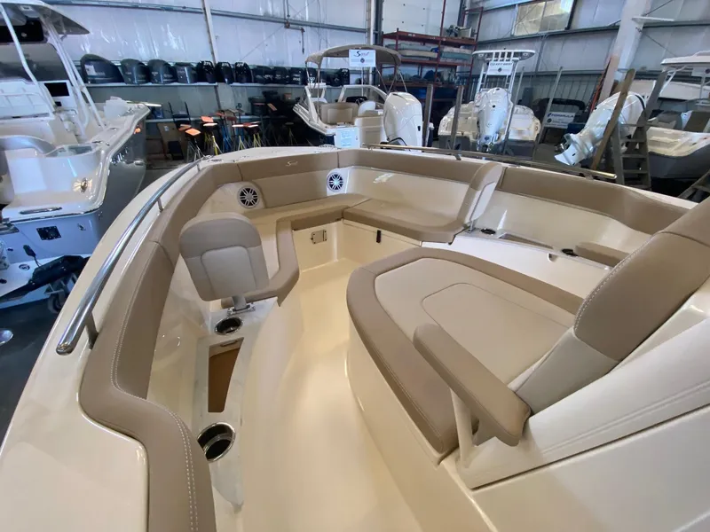 Slide: The Image of 2025 Scout 240 XSF boat interior with beige seating in a showroom. - 15