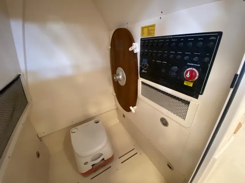 Slide: The Image of Interior of 2025 Scout 240 XSF boat with control panel and portable toilet. - 18