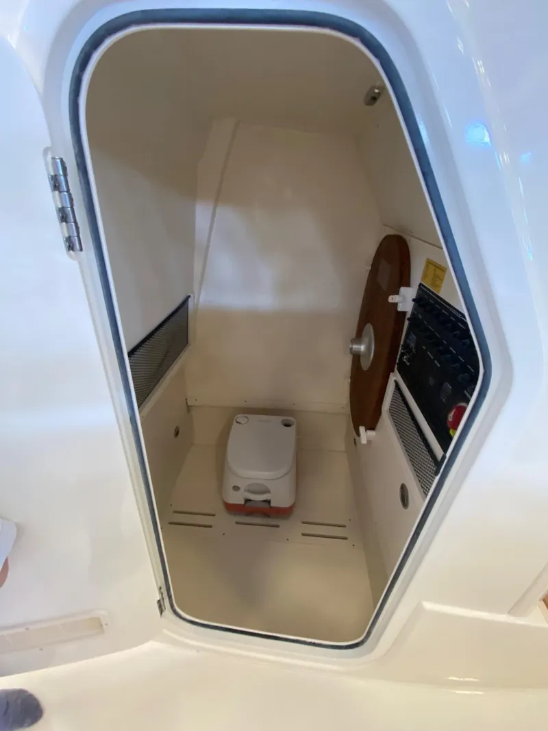 Slide: The Image of 2025 Scout 240 XSF boat interior with compact marine toilet and control panel. - 19