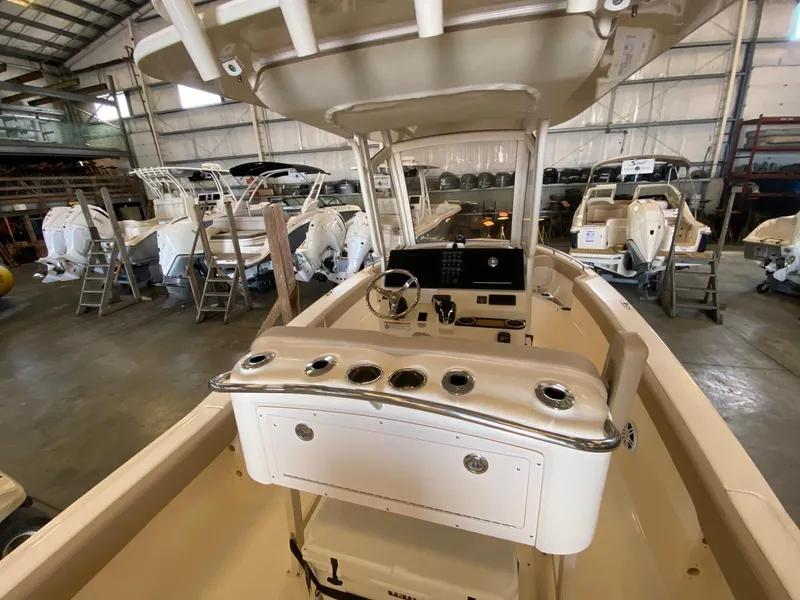 Slide: The Image of 2025 Scout 240 XSF boat interior in a showroom, showcasing helm and seating area. - 8