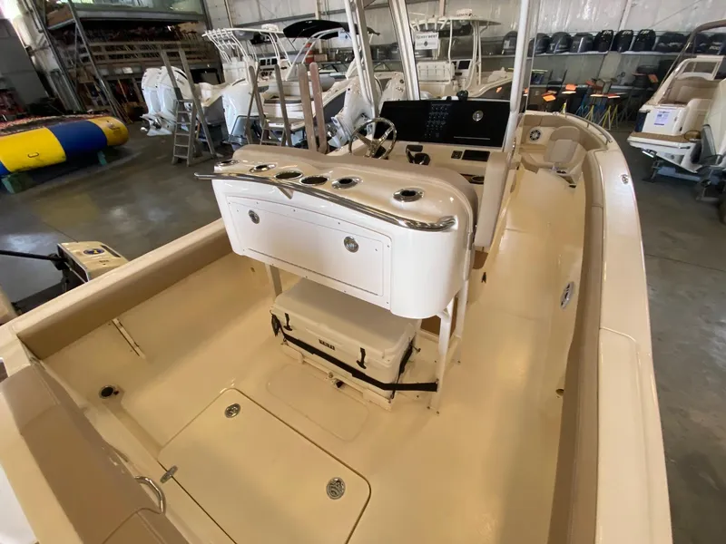 Slide: The Image of 2025 Scout 240 XSF boat interior in showroom, featuring helm and seating area. - 9