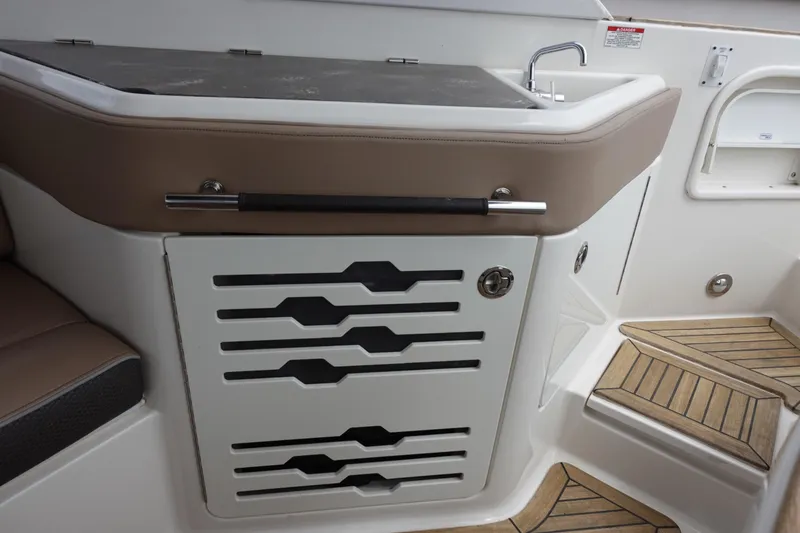 Slide: The Image of 2017 Sea Ray SLX 310 boat interior with sleek cabinetry and teak flooring. - 16