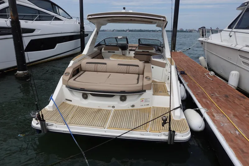 Slide: The Image of 2017 Sea Ray SLX 310 boat docked, featuring spacious seating and elegant design. - 2