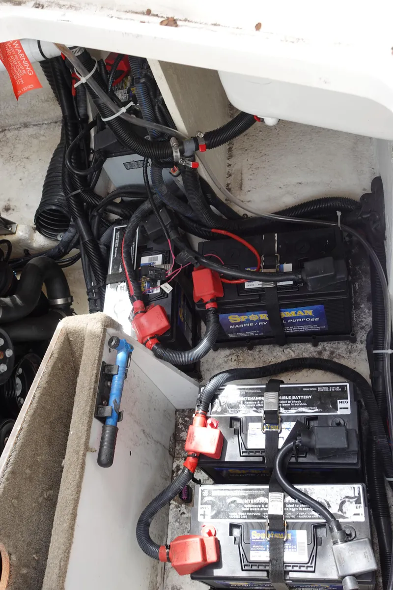 Slide: The Image of 2017 Sea Ray SLX 310 boat battery compartment with wiring and connections. - 23