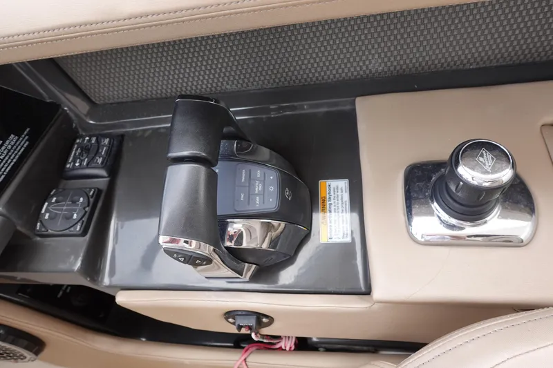 Slide: The Image of 2017 Sea Ray SLX 310 boat controls with throttle and joystick on beige console. - 6