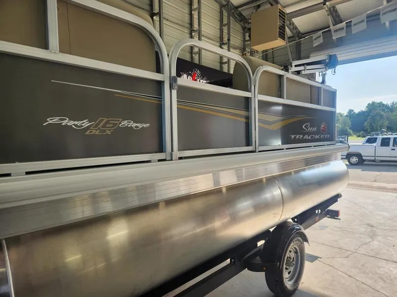 Slide: The Image of 2025 Sun Tracker PARTY BARGE® 16 DLX pontoon boat in a garage setting. - 10